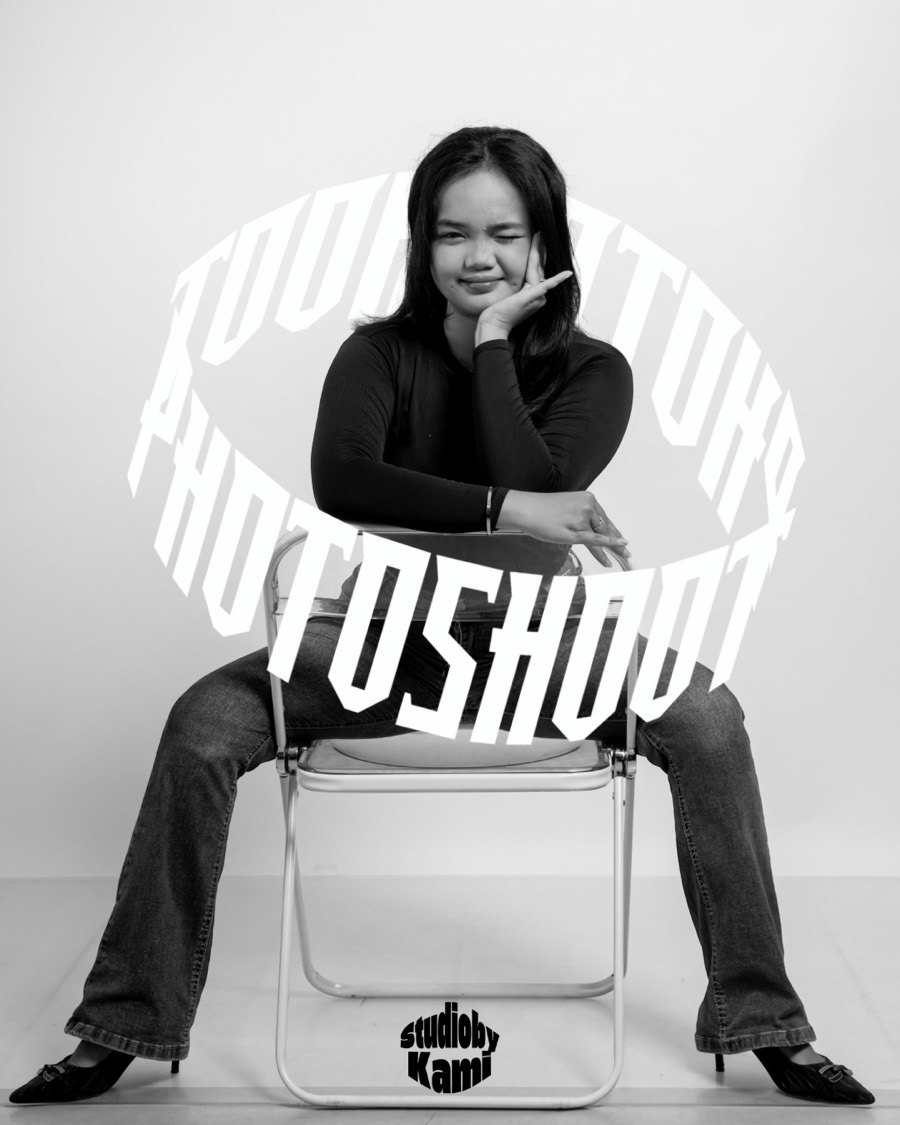 Hasil foto hitam putih: seorang perempuan duduk santai di kursi lipat studio